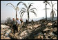 President George W. Bush is followed by Congressman Brian Bilbray as he tours a fire-ravaged neighborhood in Rancho Bernardo, California Thursday, Oct. 25, 2007. The President spent the day touring the Southern California region that has been victim to Santa Ana wind-fed wildfires since Sunday. White House photo by Eric Draper