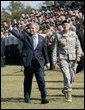 President George W. Bush waves as he and Brigadier General James Schwitters, Commanding General at Fort Jackson, S.C., walk before the graduates Friday, Nov. 2, 2007, during the President's appearance at the Basic Combat Training Graduation Ceremony. White House photo by Eric Draper