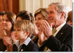 President George W. Bush and Mrs. Laura Bush are joined by Elijah Atkins, Friday, Nov. 16, 2007 in the East Room of the White House, as they listen to Atkins' father, country music star Rodney Atkins, performing for guests during the celebration of National Adoption Day. Rodney Atkins is the 2007-2008 national celebrity spokesperson for The National Council for Adoption. White House photo by Chris Greenberg