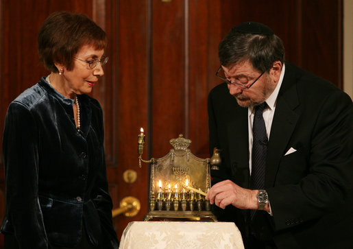A Menorah belonging to the great-grandfather of Daniel Pearl is lit by Judea and Ruth Pearl, his parents, during festivities Monday, Dec. 10, 2007, in the Grand Foyer of the White House. Said the President of the slain journalist, "His only crime was being a Jewish American -- something Daniel Pearl would never deny. Daniel's memory remains close to our hearts. By honoring Daniel, we are given the opportunity to bring forth hope from the darkness of tragedy-- and that is a miracle worth celebrating during the Festival of Lights." White House photo by Joyce N. Boghosian