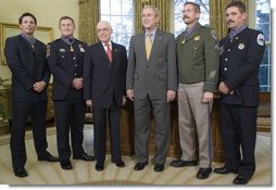 President Bush and U.S. Attorney General Michael Mukasey pose for photos with recipients of the Public Safety Officer Medal of Valor Wednesday, Dec. 12, 2007, in the Oval Office. From left are: Officer Kevin Howland of Sacramento; Officer Todd Myers of West Hartford, Conn.; Attorney General Mukasey; President Bush, Sgt. Kirk Van Orsdel of Hemet, Calif., and David Loving, a firefighter from Richmond, Va. White House photo by Chris Greenberg