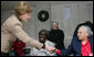 Mrs. Laura Bush reaches out for the hand of a resident of the Little Sisters of the Poor during a visit Tuesday, Dec. 18, 2007, with President George W. Bush to the Washington, D.C. facility that provides nursing and assisted living services to elderly people of lesser means. White House photo by Chris Greenberg