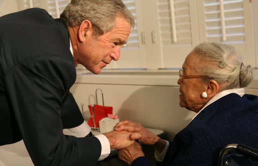 President George W. Bush speaks to a resident at the Little Sisters of the Poor of Washington, D.C., Tuesday, Dec. 18, 2007, during a visit with Mrs. Laura Bush to the facility that provides nursing and assisted-living services to elderly people of lesser means. White House photo by Shealah Craighead