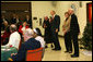 President George W. Bush draws smiles from the audience of volunteers, staff and residents at the Little Sisters of the Poor Tuesday, Dec. 18, 2007, during a visit with Mrs. Laura Bush to the Washington, D.C. facility. Enjoying the moment with them are Mother Benedict de la Passion, Superior and President of Little Sisters of the Poor, and Archbishop Donald Wuerl of the Archdiocese of Washington. White House photo by Shealah Craighead