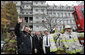 President George W. Bush joins firefighters from the District of Columbia as they wave to the media Wednesday after fighting a fire in the Eisenhower Executive Office Building on the White House complex. The charred, second-floor window frame can be seen in the upper middle of the photo. White House photo by Eric Draper