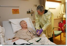 President George W. Bush visits with U.S. Army Capt. Patrick J. Horan of West Springfield, Va., at the National Naval Medical Center in Bethesda, Md., Wednesday, Dec. 19, 2007, after awarding Horan a Purple Heart medal and citation. Captain Horan is recovering from a head injury sustained in Operation Iraqi Freedom. White House photo by Joyce N. Boghosian