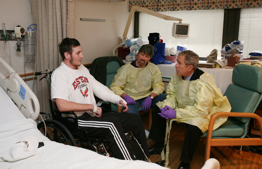President George W. Bush sits and visits with U.S. Marine Lance Cpl. Michael Stilson of Clarkson, W. Va., and his father, Robert Stilson, at the National Naval Medical Center in Bethesda, Md., Wednesday, Dec. 19, 2007. Stilson is recovering from injuries sustained in Operation Iraqi Freedom. White House photo by Joyce N. Boghosian