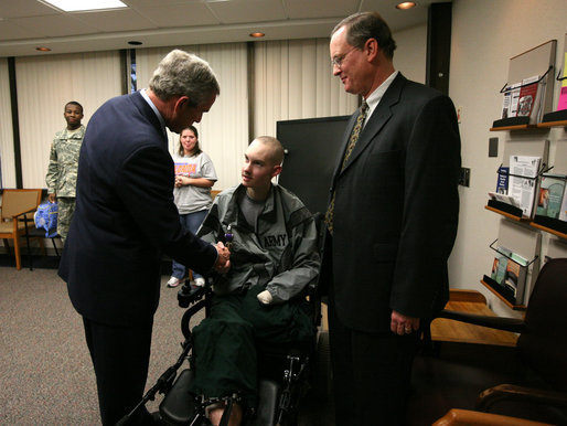 President George W. Bush presents the Purple Heart to U.S. Army Spc. John C. Hoxie of Philippi, W.Va., during a visit Thursday, Dec. 20, 2007, to Walter Reed Army Medical Center in Washington, D.C., where the soldier is recovering from injuries suffered in Operation Iraqi Freedom. Looking on is the soldier's father, David Hoxie. White House photo by Joyce N. Boghosian