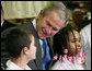 President George W. Bush talks with sixth grade student Mariano Ramos, 11, left, and seventh grader Amber McCarthy, 12, Monday, Jan. 7, 2008, during a visit to the Horace Greeley Elementary School in Chicago. White House photo by Joyce N. Boghosian