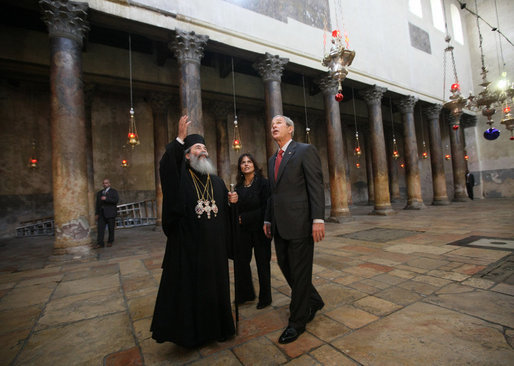 President George W. Bush listens as His Beatitude Theophilus III, Patriarch of the Greek Orthodox Patriarchate of Jerusalem, speaks during a visit to the Church of Nativi ty Thursday, Jan. 10, 2008, in Bethlehem. With them is Khouloud Daibes, Minister of Tourism. White House photo by Eric Draper