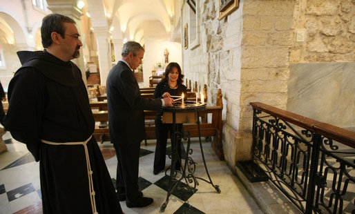 President George W. Bush lights a candle in St. Catherine’s Church during his visit to Bethlehem Thursday, Jan. 10, 2008. With him is Khouloud Daibes, Minister of Tourism, and Father Pierbattista Pizzaballa, Franciscan Custos of the Holy Land. White House photo by Eric Draper