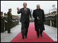 President George W. Bush waves as he and President Mahmoud Abbas of the Palestinian Authority walk the red carpet after the arrival Thursday, Jan. 10, 2008, of President Bush to Ramallah. White House photo by Chris Greenberg