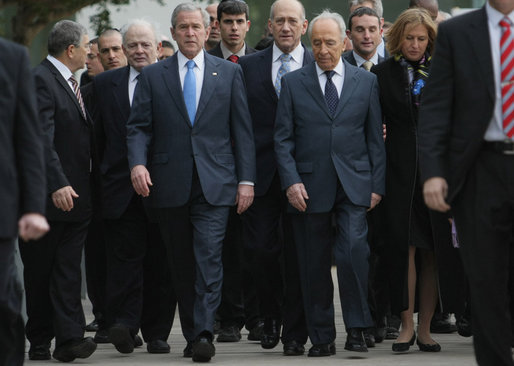 President George W. Bush walks with Israel's President Shimon Peres, right, and Prime Minister Ehud Olmert, center, as they arrive Friday, Jan. 11, 2008, to Yad Vashem, the Holocaust Museum, in Jerusalem, where the President laid a wreath in honor of Holocaust victims before departing Jerusalem for Galilee. White House photo by Eric Draper