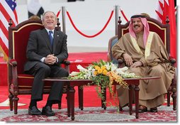 President George W. Bush and King Hamad Bin Isa Al-Khalifa break out in laughter as they sit on stage for the arrival ceremonies welcoming President Bush to Bahrain Saturday, Jan. 12, 2008, in Manama. White House photo by Eric Draper