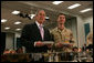 President George W. Bush stands with SN Kevin Key of Wisconsin during breakfast Sunday with military personnel and coalition forces at the U.A Naval Forces Central Command in Manama, Bahrain. White House photo by Chris Greenberg