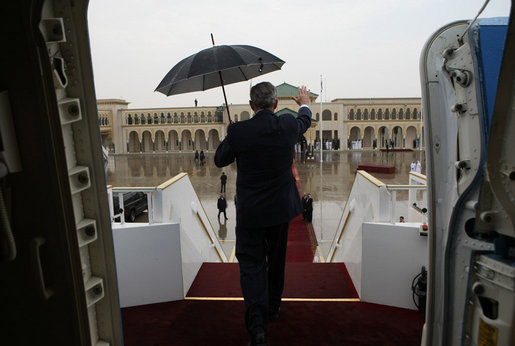 With umbrella in hand, President George W. Bush waves from aboard Air Force One as he prepares to deplane after arriving Sunday, Jan. 13, 2008, at Abu Dhabi International Airport. White House photo by Eric Draper