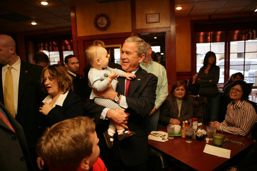President George W. Bush gets up close and personal with a child as he arrived Friday, Feb. 1, 2008, at Eggtc., a home-style restaurant in Kansas City, where he met local business leaders over breakfast. White House photo by Eric Draper