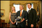 President George W. Bush holds a racing helmet as he poses with 2007 NASCAR Nextel Cup Champion Jimmie Johnson and wife, Chandra Johnson Tuesday Feb. 5, 2008, in the Oval Office. White House photo by Chris Greenberg