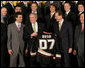 President George W. Bush stands between Scotty Niedermayer, left, and Ducks' owner Henry Samueli as he holds up a BUSH 07 Anaheim Ducks jersey Wednesday, Feb. 6, 2008, after welcoming the 2007 Stanley Cup champions to the East Room of the White House. White House photo by Eric Draper