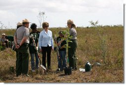 Mrs. Laura Bush joins Florida City Elementary School students Cornesha Dericho, left, and Dania Amaya, along with park ranger Allyson Gantt, right, as they prepare to plant a Gumbo Limbo tree Wednesday, Feb. 6, 2008, during the Junior Ranger "First Bloom" planting event in Everglades National Park, Fla. Mrs. Bush praised the Everglades restoration program which hopes to plant native trees to replace invasive species that are choking the park. White House photo by Shealah Craighead