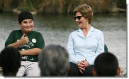 Mrs. Laura Bush smiles as a Florida City Elementary School student gives a thumbs-up while sitting on stage with Mrs. Bush, Wednesday, Feb. 6, 2008, during the Junior Ranger “First Bloom” planting event in Everglades National Park, Fla. Mrs. Bush praised the Everglades restoration program which will help bring back native trees in areas of the Everglades overgrown with non-native plants. White House photo by Shealah Craighead