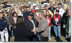 President George W. Bush holds the hands of Phil and June Spears after touring their Lafayette, Tennessee neighborhood Friday, Feb. 8, 2008. The President assured the Spears that they'd receive the care they needed in the wake of Tuesday's deadly tornadoes, and said, "And you're going to find you got some new friends showing up, too. When they know there's a neighbor in need, they'll come and help you." White House photo by Chris Greenberg