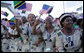 Tanzanian women in dresses bearing the likeness of President George W. Bush wave flags from Tanzania and the United States as they await the arrival Saturday, Feb. 16, 2008, at Julius Nyerere International Airport in Dar es Salaam of President Bush and Mrs. Laura Bush. White House photo by Chris Greenberg