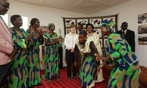 Mrs. Laura Bush and Madame Chantal de Souza Yayi, First Lady of Benin, enjoy the dancing by members of the USAID-Supported Mothers’ Association as the two women are greeted Saturday, Feb. 16, 2008, after the arrival of Mrs. Bush and President George W. Bush to Benin. White House photo by Shealah Craighead