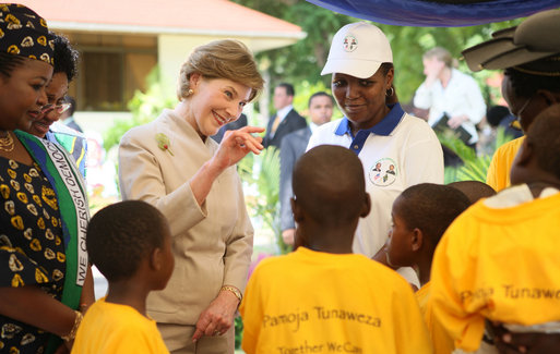 Mrs. Laura Bush waves to a child as she tours the stations of the WAMA Foundation in Dar es Salaam Sunday, Feb. 17, 2008. The Foundation is a non-profit founded by Mrs. Salma Kikwete, First Lady of Tanzania, focusing on development by improving women’s social and economic status by redefining gender roles and creating more opportunities for the development of women and children. White House photo by Shealah Craighead