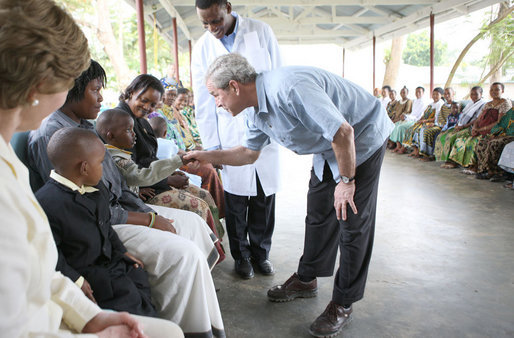 President George W. Bush greets a young child on his arrival Monday, Feb. 18, 2008, for a tour of the outpatient clinic of the Meru District Hospital in Arusha, Tanzania. White House photo by Eric Draper