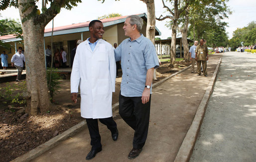 President George W. Bush walks with Dr. Aziz Msuya Monday, Feb. 18, 2008, during a tour of the Meru District Hospital outpatient clinic in Arusha, Tanzania. White House photo by Eric Draper