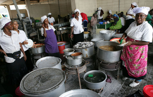 Women work serving dishes of fish, rice and beans at the fish market, Monday, February 18, 2008 in the Tanzanian capitol of Dar es Salaam. White House photo by Chris Greenberg
