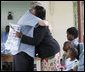 President George W. Bush embraces a pregnant woman after presenting her with a mosquito net during a tour Monday, Feb. 18, 2008, of the Meru District Hospital outpatient clinic in Arusha, Tanzania. The presentation of mosquito nets is part of a program to help in the battle against malaria. White House photo by Eric Draper