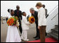 President George W. Bush and Mrs. Laura Bush are greeted by children with flowers on their arrival Tuesday, Feb. 19, 2008 to Kigali International Airport in Kigali, Rwanda. White House photo by Eric Draper