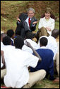 President George W. Bush and Mrs. Laura Bush react during a discussion with members of the Lycee de Kigali 'Anti-AIDS Club' Tuesday, Feb. 19, 2008, outside of the Lycee de Kigali in Kigali, Rwanda. White House photo by Eric Draper