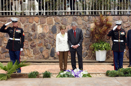 Flanked by saluting U.S. Marines President George W. Bush and Mrs. Laura Bush pause for a moment of silence after laying a wreath on a mass grave at the genocide memorial Tuesday, Feb. 19, 2008, at the Kigali Memorial Centre in Kigali, Rwanda. White House photo by Eric Draper