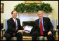 President George W. Bush receives a copy of the "Quiet Revolution" report Monday, Feb. 25, 2008, from Jay Hein, Director of the Office of Faith-Based and Community Initiatives, during a morning meeting in the Oval Office. White House photo by Joyce N. Boghosian