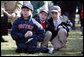Young kids sit in awe wearing Boston Red Sox caps and holding baseballs hoping to get autographs during the Red Sox visit to the White House Wednesday, Feb. 27, 2008, on the South Lawn. White House photo by Chris Greenberg
