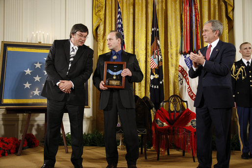 President George W. Bush applauds after presenting the Medal of Honor posthumously to family members of U.S. Army Master Sgt. Woodrow Wilson Keeble, Monday, March 3, 2008 in the East Room of the White House, in honor of Master Sgt. Keeble’s gallantry during his service in the Korean War. Kurt Bluedog, left, Keeble’s great nephew, and Russ Hawkins, a step-son, accepted the award honoring Keeble, the first full-blooded Sioux Indian to receive the Medal of Honor. White House photo by Eric Draper
