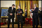 President George W. Bush applauds after presenting the Medal of Honor posthumously to family members of U.S. Army Master Sgt. Woodrow Wilson Keeble, Monday, March 3, 2008 in the East Room of the White House, in honor of Master Sgt. Keeble’s gallantry during his service in the Korean War. Kurt Bluedog, left, Keeble’s great nephew, and Russ Hawkins, a step-son, accepted the award honoring Keeble, the first full-blooded Sioux Indian to receive the Medal of Honor. White House photo by Eric Draper