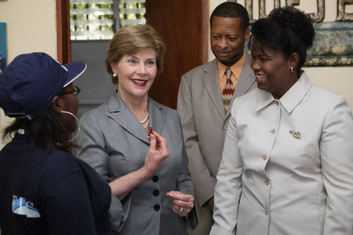Mrs. Laura Bush, joined by Guerda Previlon, right, chief of party IDEJEN, and Gabriel Bienime, Haiti Education Minister, visits with a student enrolled in the IDEJEN educational program at the College de St. Martin Tours Thursday, March 13, 2008, in Port-au-Prince, Haiti. In an address to the faculty and staff Mrs. Bush said, “Educating its young people is one of the best things a country can do to ensure its continued development.” White House photo by Shealah Craighead