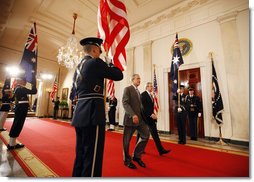 President George W. Bush and Australian Prime Minister pass an honor guard as the walk together through the Cross Hall Friday, March 28, 2008, after a joint press availability in the East Room of the White House. White House photo by Eric Draper