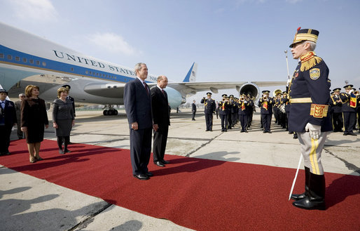 President George W. Bush stands with President Traian Basescu of Romania, during welcoming ceremonies Wednesday, April 2, 2008, at Mihail Kogalniceanu Airport in Constanta, Romania. With them on the red carpet are Mrs. Laura Bush and Mrs. Maria Basescu. White House photo by Eric Draper