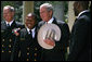 President George W. Bush is presented a cowboy hat and a Commander-in-Chief Trophy ring by Co-Captains Reggie Campbell, left, and Irv Spencer Monday, April 14, 2008, during the presentation of the Commander-in-Chief's Trophy to the United States Naval Academy Football Team in the Rose Garden at the White House. White House photo by Noah Rabinowitz