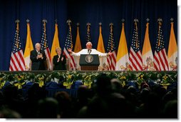 Pope Benedict XVI, joined on stage by Vice President Dick Cheney and Mrs. Lynne Cheney, gestures to the faithful Sunday, April 20, 2008 at a farewell ceremony for the Pope at John F. Kennedy International Airport in New York.  White House photo by Shealah Craighead