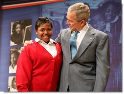 President George W. Bush stands with his arm around Aysia Mayo-Gray, a student at St. Ann's Academy in Washington, D.C., and one of the greeters on hand to welcome the President to the White House Summit on Inner-City Children and Faith-Based Schools Thursday, April 24, 2008, at the Ronald Reagan Building and International Trade Center. Said the President after being introduced by the 14-year-old, "Aysia, thanks for the introduction -- you did a fabulous job. I'm told that your's a very hard worker who loves school, and it's clear you always wear a smile."  White House photo by Chris Greenberg