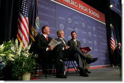 President George W. Bush shares a smile with Greensburg Schools Superintendent Darin Headrick, (left), and Greensburg High Principal Randy Fulton, during commencement ceremonies for the Greensburg High School graduating class of 2008. The town of Greensburg, KS was almost entirely destroyed when a tornado tore through the town one year ago today. White House photo by Chris Greenberg