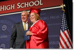 President George W. Bush shares a smile with Megan Booth after presenting her with her diploma during commencement ceremonies for the Greensburg High School Class of 2008. The town of Greensburg, KS was almost entirely destroyed when a tornado tore through the town one year ago today. White House photo by Chris Greenberg