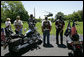 Members of the motorcycle group Rolling Thunder watch President George W. Bush and First Lady Laura Bush land on the South Lawn of the White House from a visit to Camp David. White House photo by Chris Greenberg