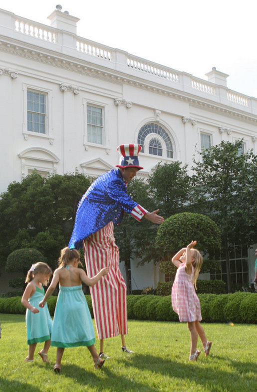 Uncle Sam on stilts reaches out to slap high-five with children at the annual Congressional Picnic on the South Lawn of the White House, Thursday evening, June 5, 2008. White House photo by Grant Miller
